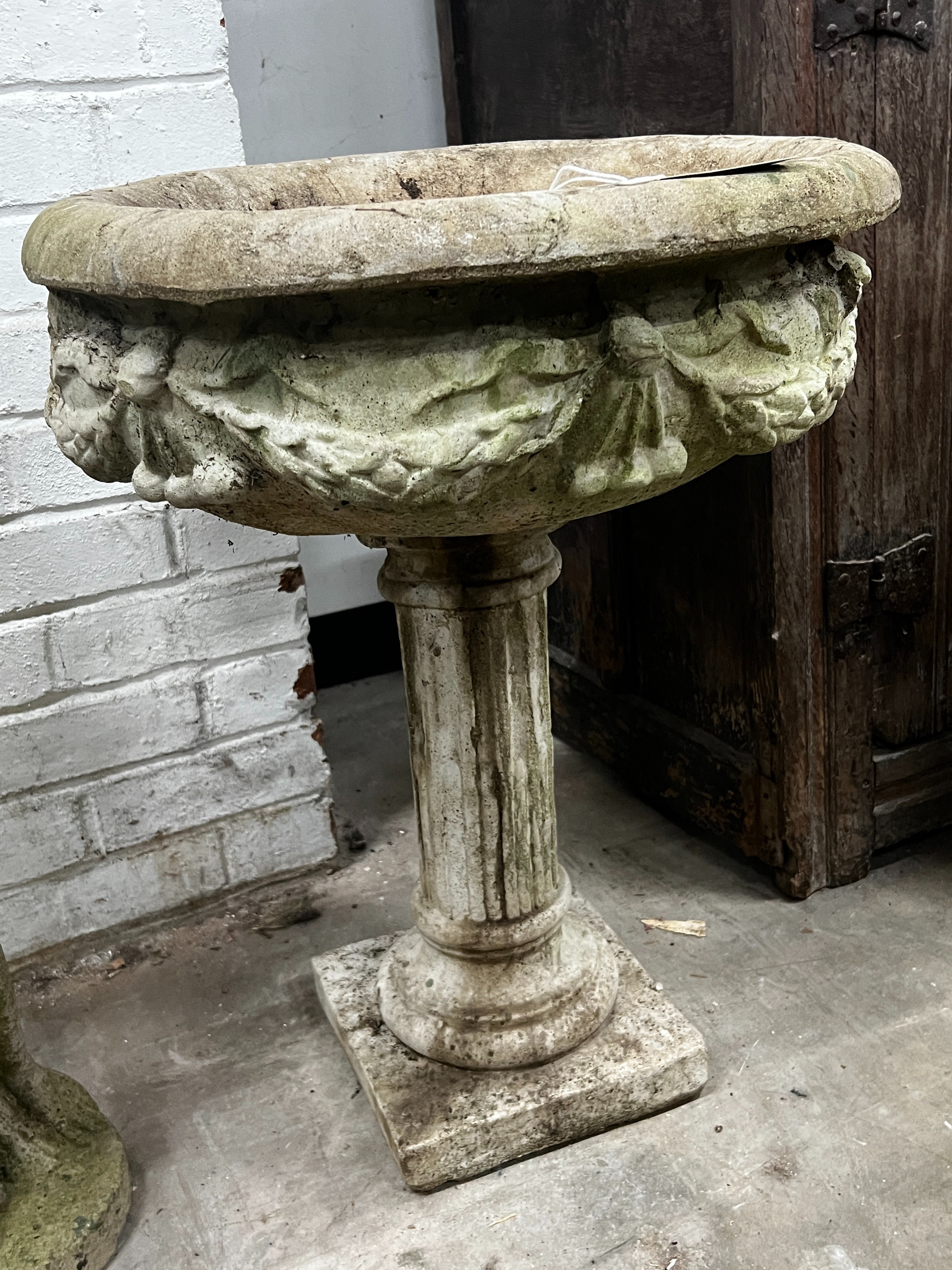 A reconstituted stone circular garden planter, width 49cm, height 65cm